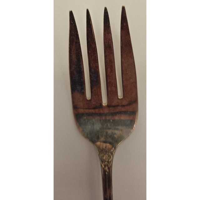 Wm. Rogers & Son vintage silverplate serving fork measuring 8.5 inches, featuring a detailed floral pattern on the handle....