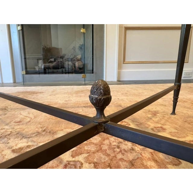 Elegant vintage Neoclassical coffee table in the manner of Maison Jansen, featuring a rectangular clear glass top set...