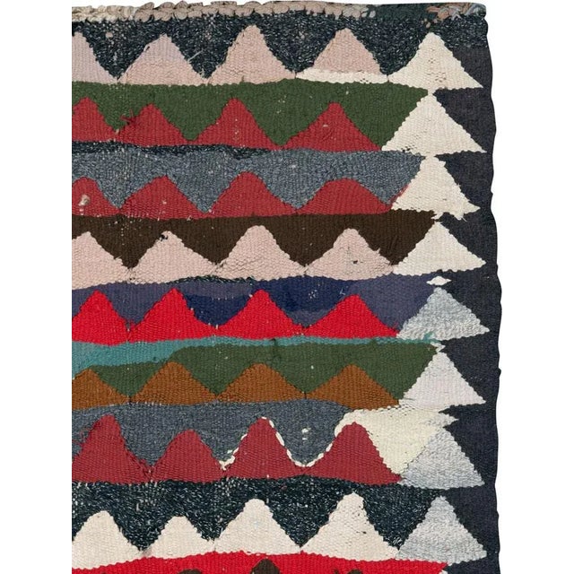 A vintage Persian flat-woven Kilim rug from the mid-20th century. A Kilim is a flat tapestry-woven carpet or rug...