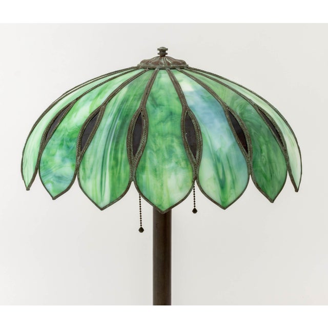 Tiffany Style Slag Glass Table Lamp, the floriform shade with green slag glass panels, the patinated bronzed base cast...