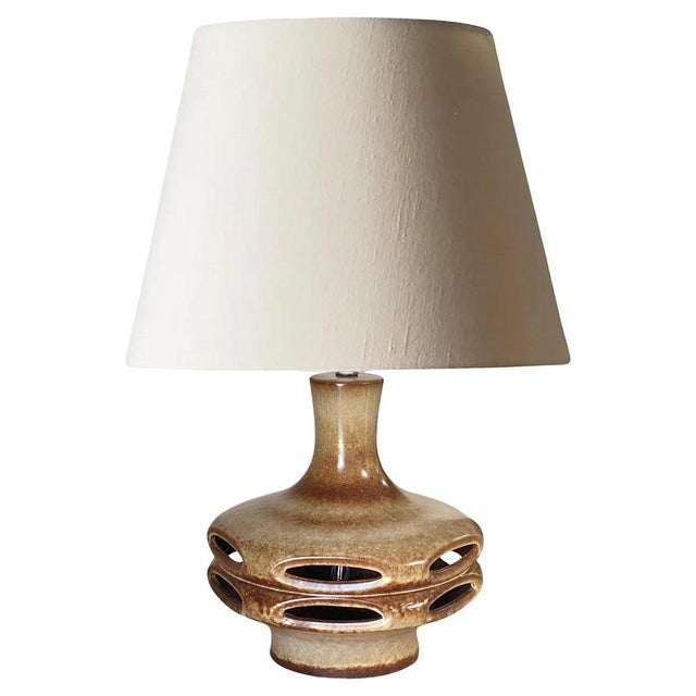 This lamp has been made in germany, in the 1970s. The ceramic is old patinated, \. Brown color. The shades are not...