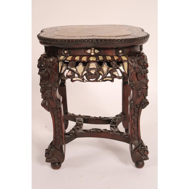 Chinese rosewood taboret with mother of pearl inlay and a marble top, circa 1920's. With an inset marble top bordered by...