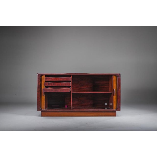 Elegant Danish vintage sideboard by Dyrlund, crafted in richly grained rosewood and featuring smooth sliding tambour...