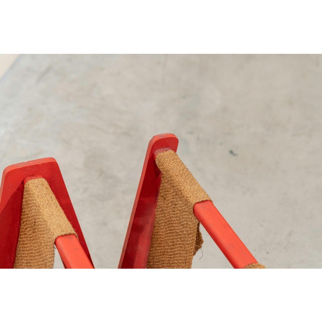 "W" shaped umbrella stand with two compartments made of red lacquered wood and burlap.