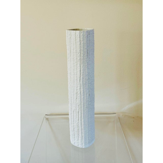 A slender white porcelain vase with textured surface. From workshop of Thomas, Germany a division of Rosenthal. An example...