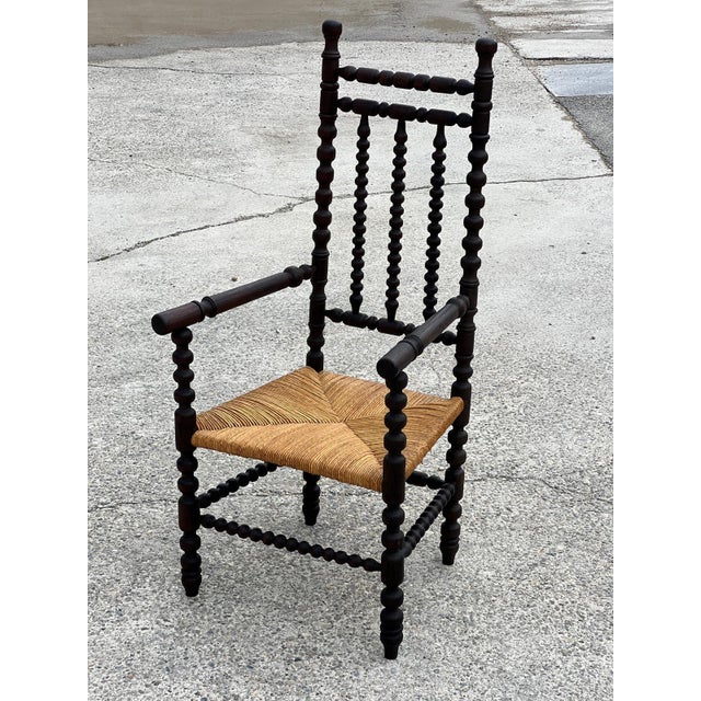 High armchair in turned and stained oak, known as a Bobbin chair, with a straw seat. Very good condition. Probably French....