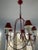 Add a bold pop of French-inspired charm to your space with this striking six-light red wrought iron chandelier. This...