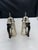 Matching silverplate coffee pots with hinged lids and black handles. The set includes one pot with a spout and one...