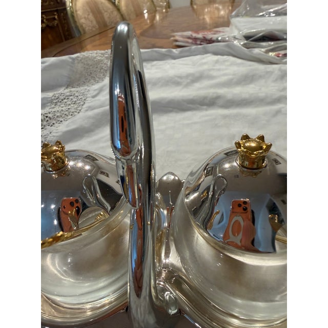 An elegant vintage salt and pepper serving set featuring two rounded frosted glass cellars nestled in a sculptural, highly...