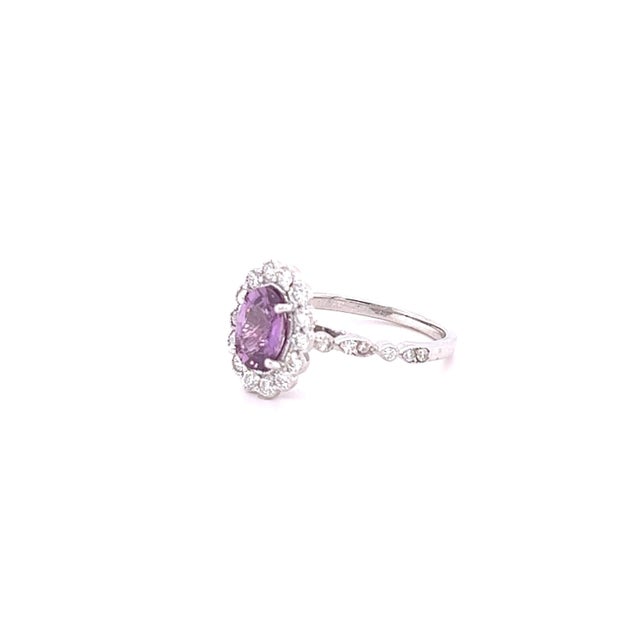 This beautiful ring has a Natural Oval Cut Purplish Pink Sapphire that weights 1.36 Carats. The ring is embellished with...