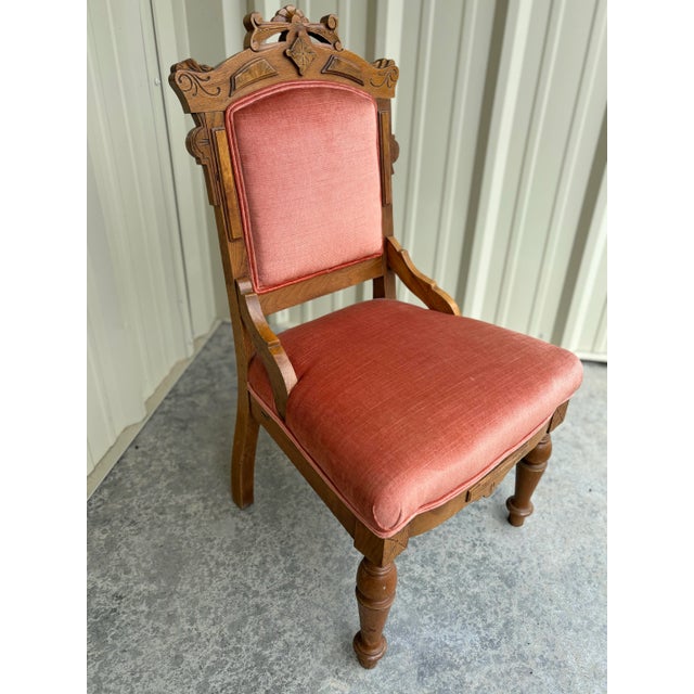 A beautifully carved antique Victorian Eastlake side chair dating to the 1920s, featuring an elegant solid mahogany frame...