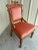 A beautifully carved antique Victorian Eastlake side chair dating to the 1920s, featuring an elegant solid mahogany frame...