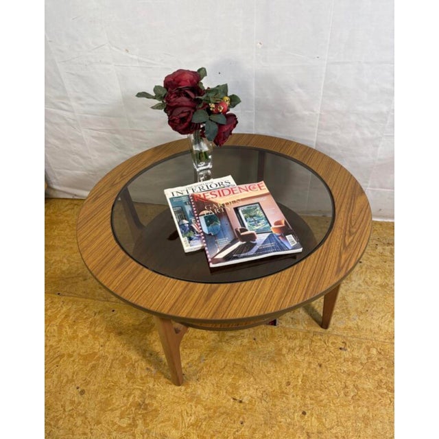 A stylish and elegant mid century modern round coffee table dating from the 1960s–1970s, offering timeless design and...