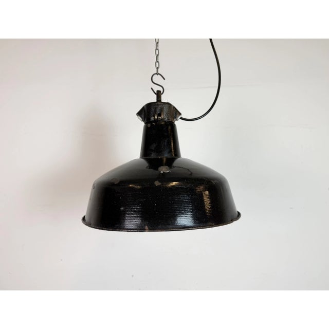 Industrial black enamel pendant light made by Elektrosvit in former Czechoslovakia during the 1950s. White enamel inside...