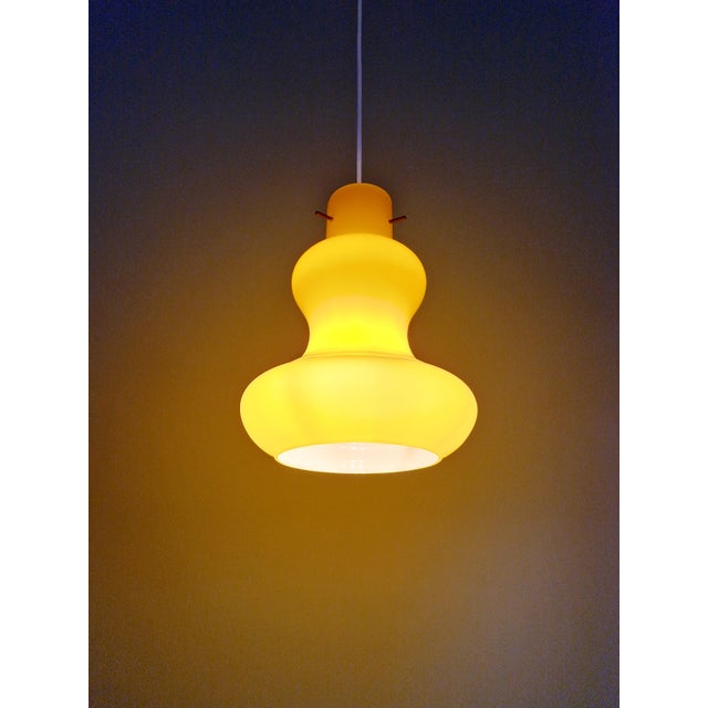 Vintage pendant light with an organic shape, made of yellow opaline glass, produced in Italy in the 1960s-70s. The pendant...