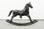 A vintage decorative handmade hammered iron rocking horse with a sleek black finish and delightful details like a saddle...