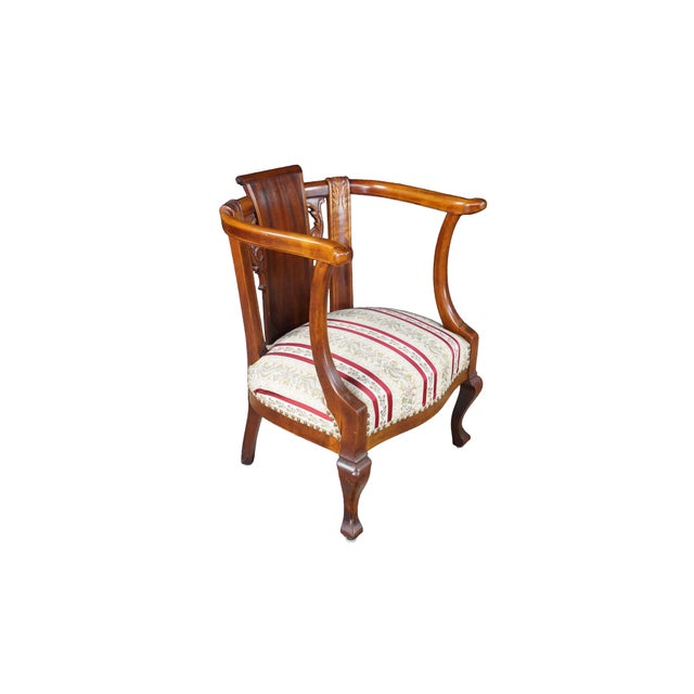 An exceptional 19th-century antique mahogany armchair masterfully combining the dramatic, sweeping lines of the Empire and...