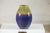This richly glazed ceramic vase displays a striking contrast of colors and textures, with a bold palette that moves from...