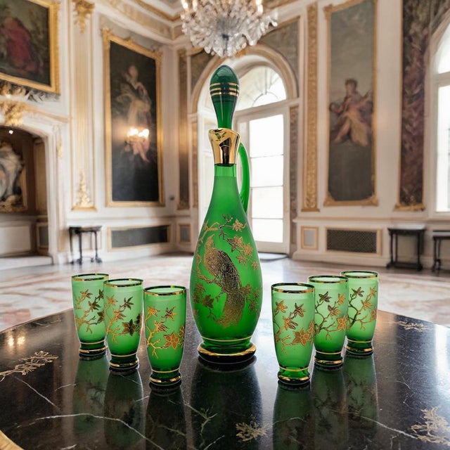 A refined mid-century barware set featuring a tall frosted emerald glass decanter with six coordinating cordial glasses,...