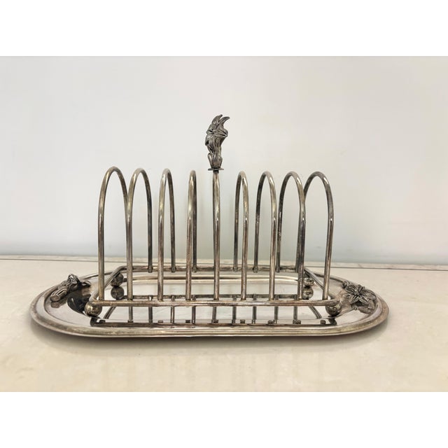 A lovely English style silver-plate eight slice toast rack with crumb tray. Classy piece with floral details. Wonderful...