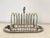 A lovely English style silver-plate eight slice toast rack with crumb tray. Classy piece with floral details. Wonderful...