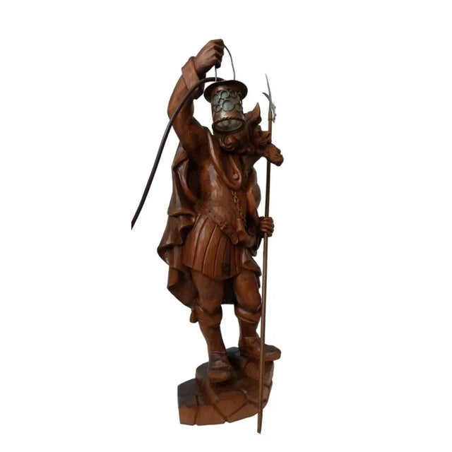 A masterfully hand-carved wooden lamp features a beautiful sculpture of a night watchman with a lantern and halberd. The...