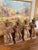 A cohesive set of four hand-carved wooden figurines depicting seated folk musicians, each holding a different instrument....