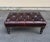 George Smith ottoman in dark brown tufted leather with mahogany wood turned legs.