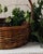 A beautifully aged vintage gathering basket with a low oval form, tall arched handle and richly variegated brown finish....