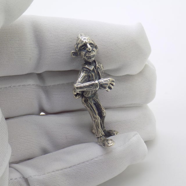 Full of human warmth and nostalgic narrative charm, this vintage silver figurine depicts an elderly man engaged in a game...