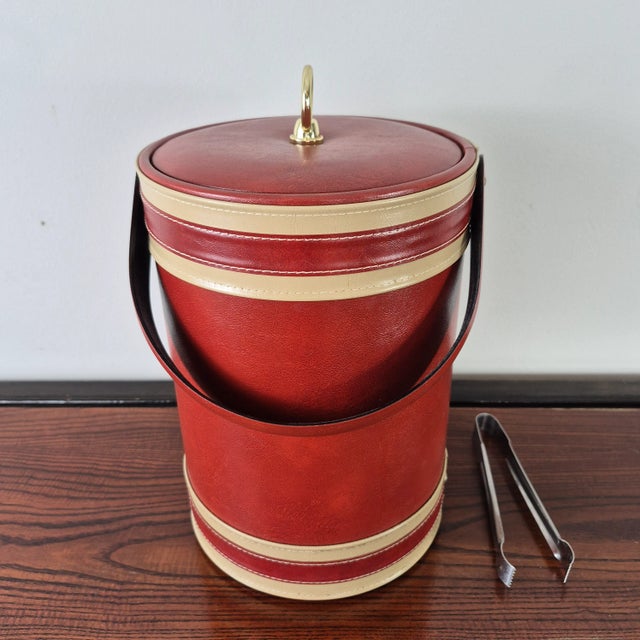 Vintage red faux leather tall ice bucket signed Georges Briard. The ice bucket is insulated inside and has a lid and a...