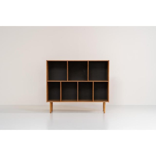 Oak bookcase by Kurt Østervig (Denmark, 1960s). A minimalistic bookcase crated in oak with vertical adjustable shelves and...