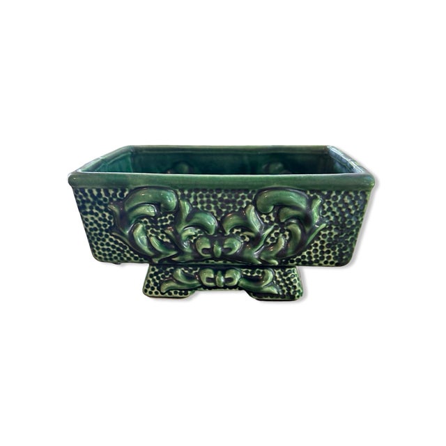 Vintage bisque ceramic green floral planter, from the 50’s. There is a bow scroll embossed design on either side, and on...
