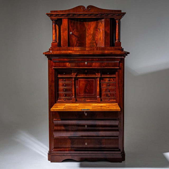 Large Biedermeier secretary cabinet with a shaped apron, rounded corners, and three lower drawers. Above are a flat fall-...