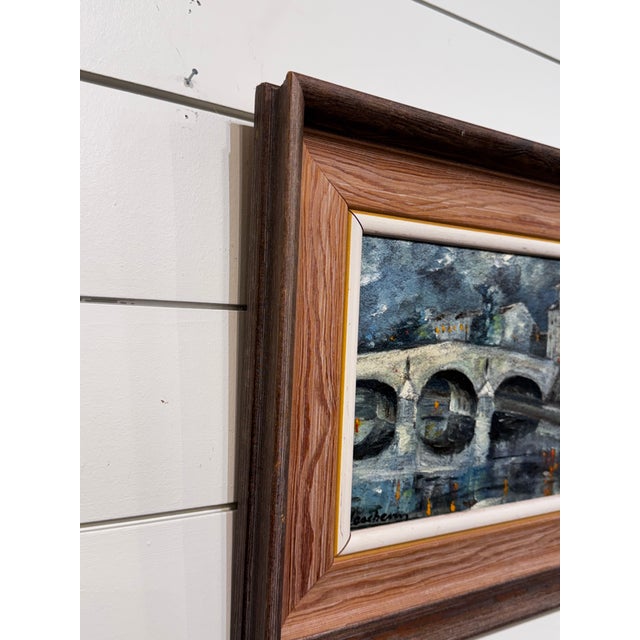 This oil on canvas from the early 20th Century depicting a canal bridge over water, it has deep and moody brushstrokes and...