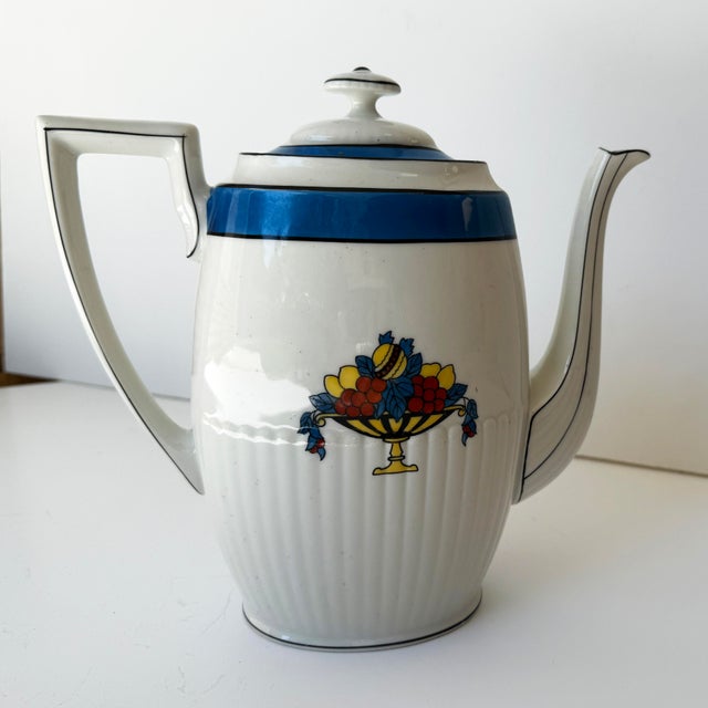 Elegant French Art Deco TLB Limoges porcelain teapot featuring a distinctive ribbed body, wide cobalt blue band, and...