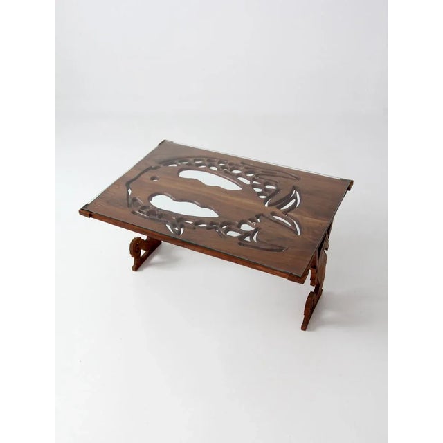 A vintage coffee table from 1988 with a playful ocean-inspired design. Artist-signed, the carved wood table features...
