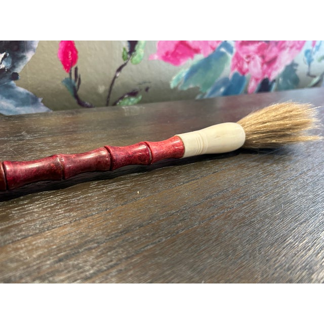 This is a decorative Chinese calligraphy brush, used as a home decor accent. The handle is crafted from red, sectioned...