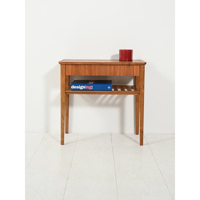 Light lines from the 1950s and 1960s, tapered legs, and a slatted shelf: a warm balance between teak and beech. Vintage...