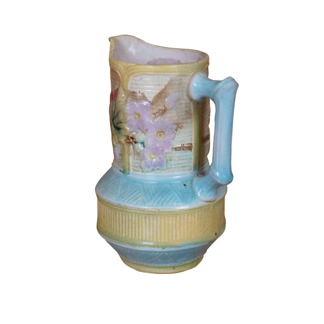 Antique Majolica pitcher or jug featuring a chinoiserie bamboo and basketweave design with dogwood flower. Marked on base....