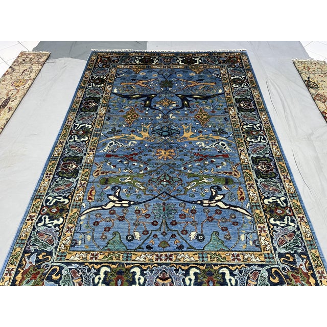 This blue Afghan Sultani wool area rug features a Persian Bijar-inspired design filled with sweeping botanical motifs,...