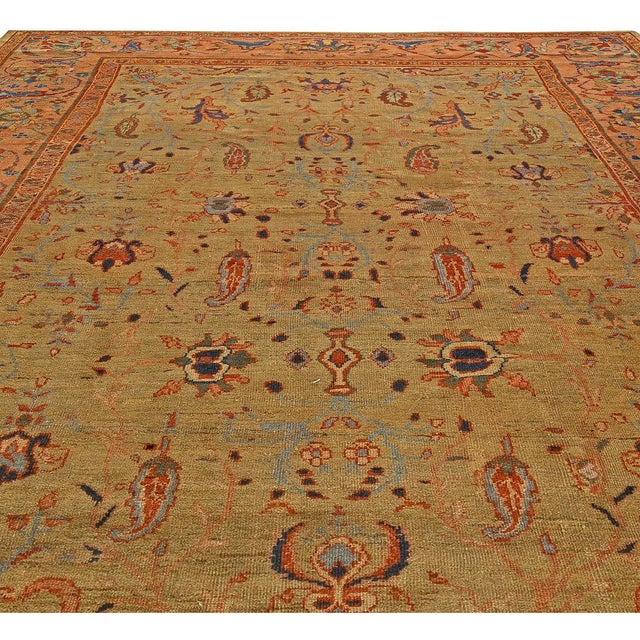 This circa-1920 antique Persian Sultanabad area rug features an all-over design of floral motifs and abstractions in...
