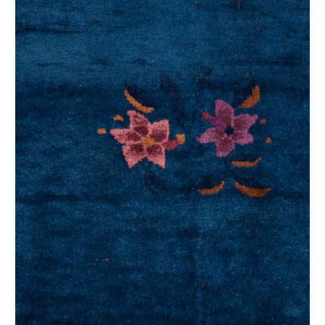 An early 20th century Chinese Art Deco rug with a beautiful indigo background surrounded by a complementary border with a...