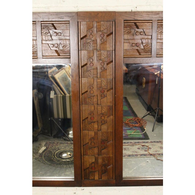 Large wall mirror with mosaic wood carved pattern. A "T" shaped design that splits the mirror in half. Warm walnut wood...