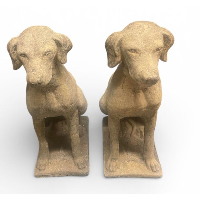 A handsome pair of vintage cast stone (reconstituted stone) statues depicting alert hunting dogs in a seated pose....