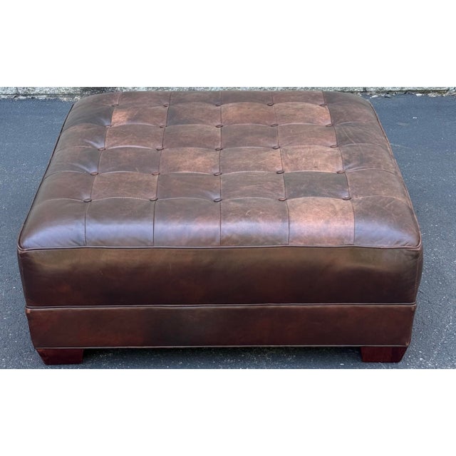 Handsome ottoman meticulously crafted in supple leather by Lee industries. Features a tufted design, square shape and...