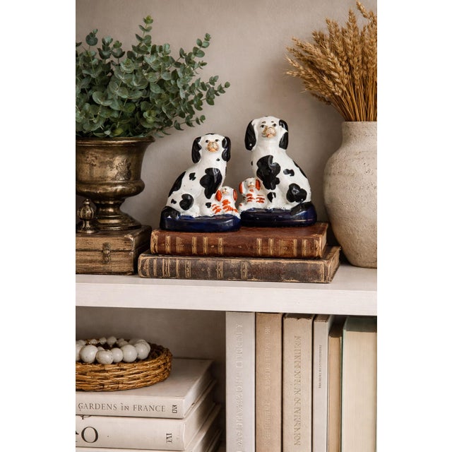 Late 19th century pair of English Staffordshire dogs with pups, featuring classic hand-painted decoration and traditional...