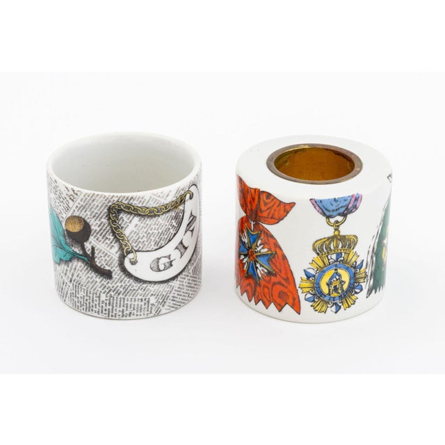 Two Fornasetti Porcelain Tableware Pieces, comprising: lighter in medallion pattern and jar with gin liquor label and...
