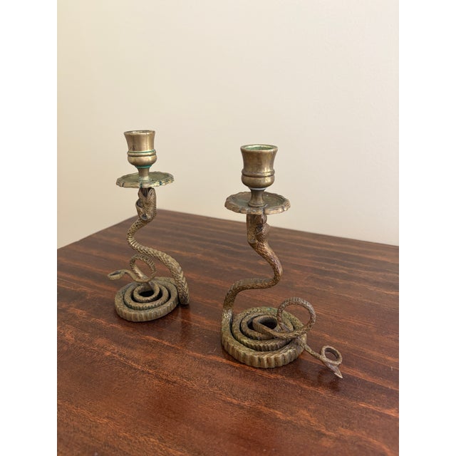 A striking pair of antique French brass serpent candle holders dating to the 1920s, sculpted with elegantly coiled bodies...