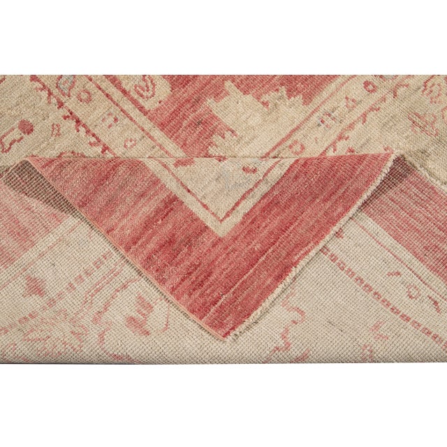 Beautiful Modern Turkish hand-knotted wool rug with a red field. This rug has a designed blue frame with multicolor...